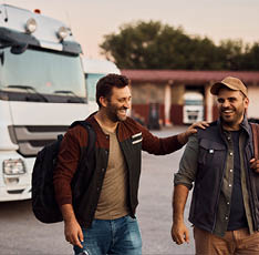 Happy drivers having fun after work on truck parking lot.